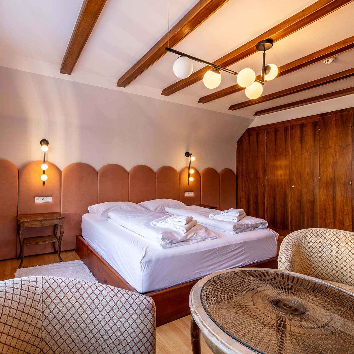 großes Zimmer mit Doppelbett und Sessel