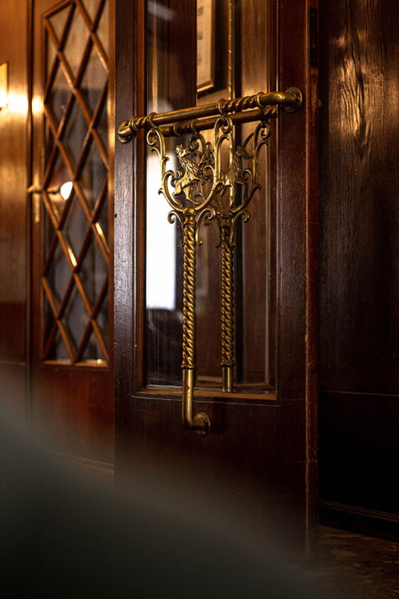 Detail hölzerne Eingangstür mit goldenem Türgriff