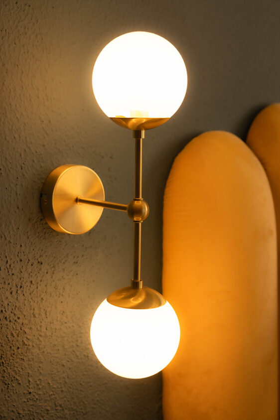 Detail Lampe neben gelben Bettrücken