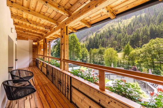 Balkon mit zwei Stühlen und Ausblick auf einen Berg