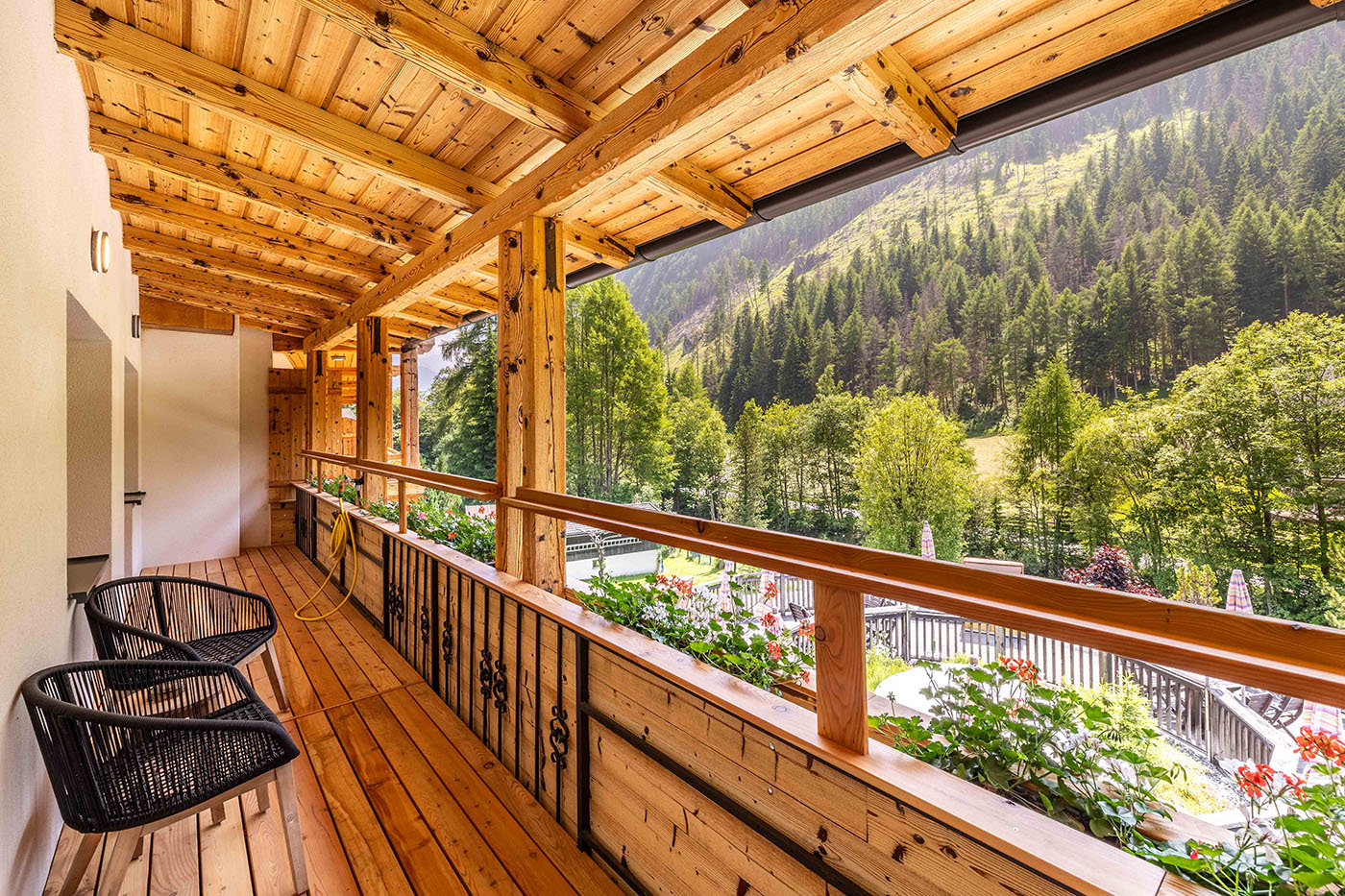 Balkon mit zwei Stühlen und Ausblick auf einen Berg