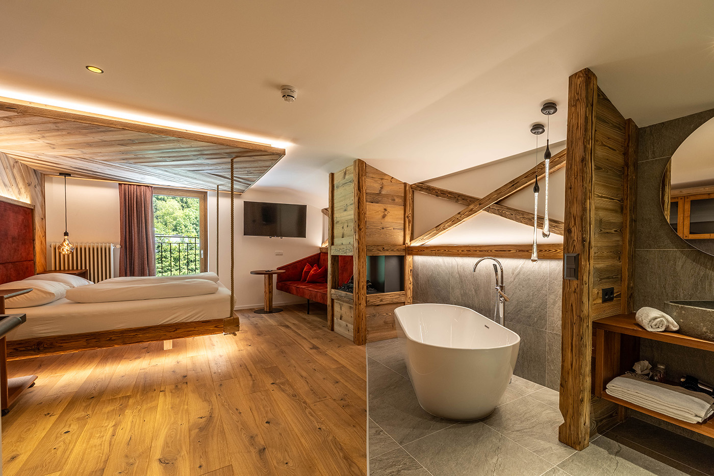 Offener Raum mit Badewanne und Doppelbett