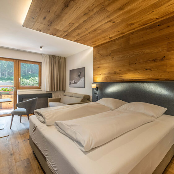 Doppelbett vor Fenster mit Aussicht auf die Berge