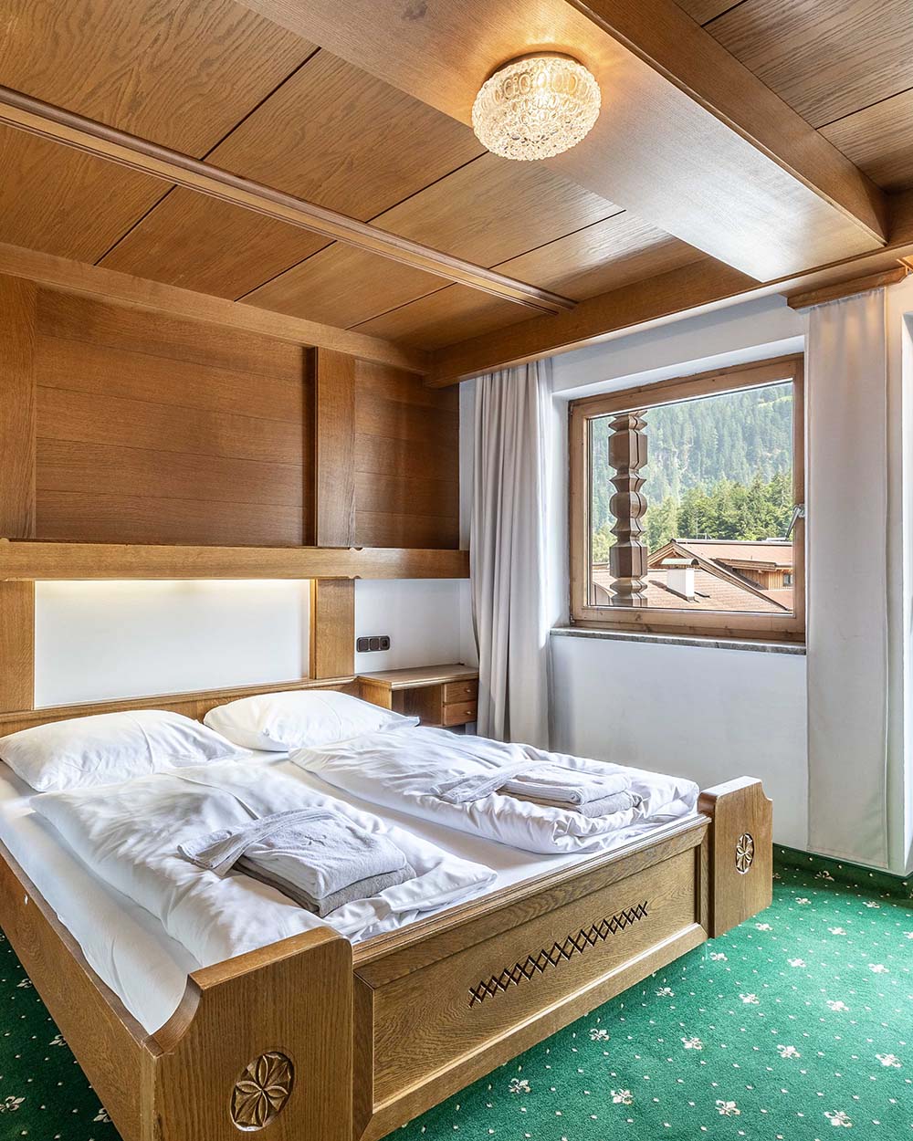 Zimmer mit Doppelbett vor einem Fenster